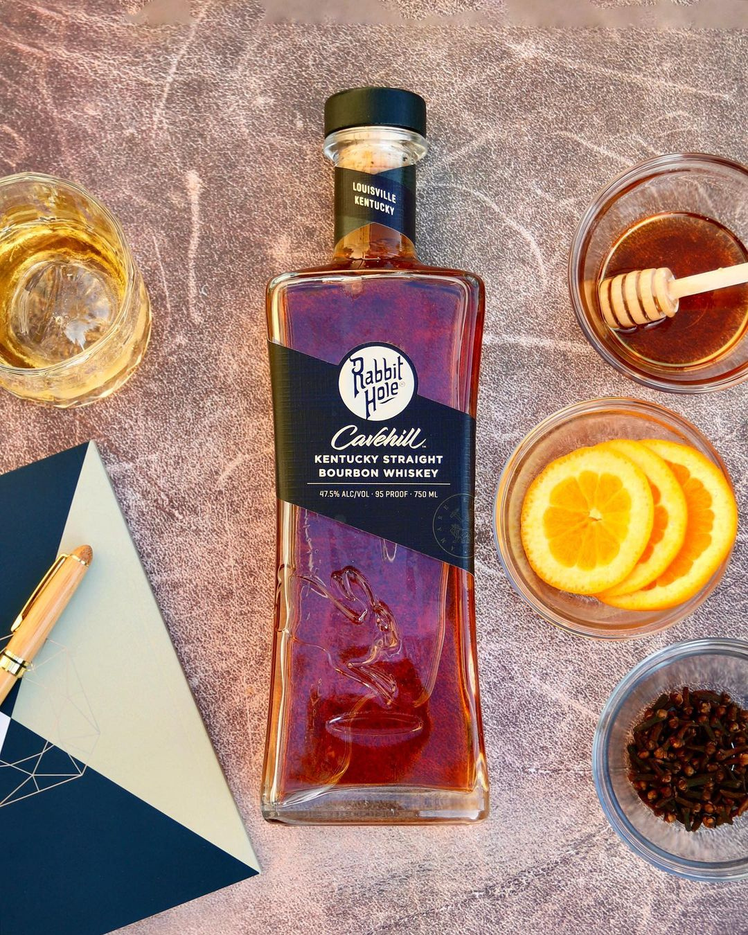 Rabbit Hole Cavehill bourbon flat lay with honey, orange, and cloves